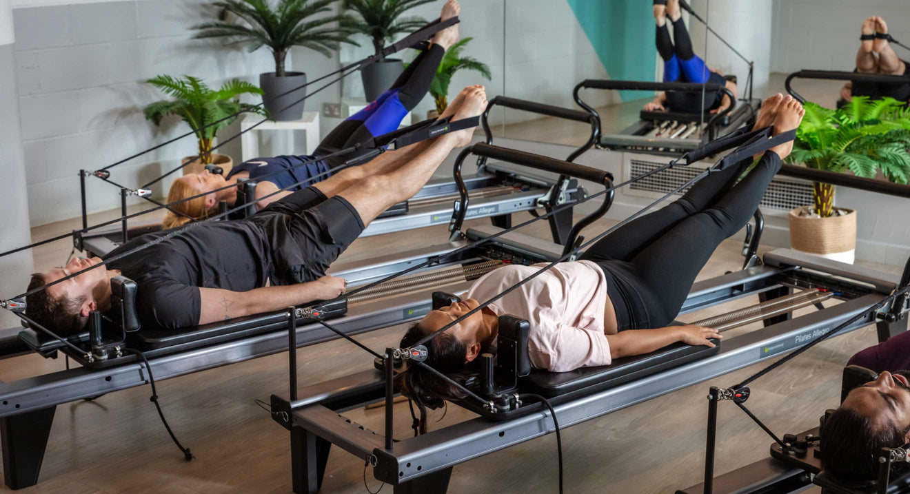 Premium Photo  Pilates training for legs woman using fitness ball while  exercising on pilates reformer